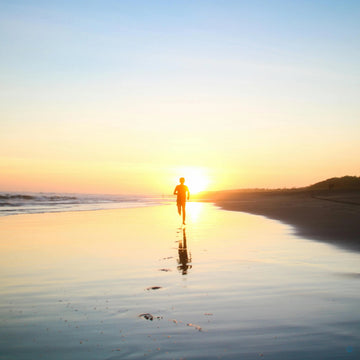 Läufer am Strand bei Sonnenuntergang