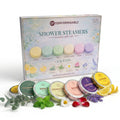Sechs Shower Steamers von Comformidable mit Kräutern und Blüten auf weißem Hintergrund